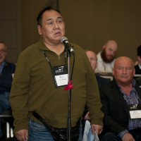 A delegate ask questions during a conference session.
